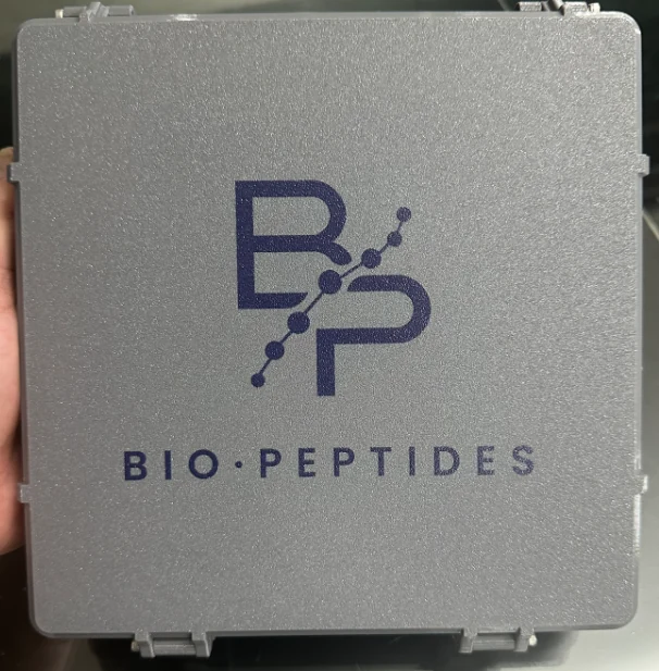 Estuche grande gris Bio·Peptides con la marca impresa en azul marino